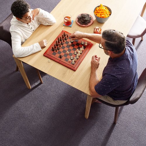 Father is playing chess with son